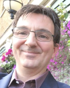 Alan smiling, in smart shirt and jacket