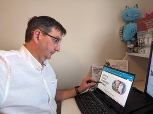 Alan sitting in front of a laptop